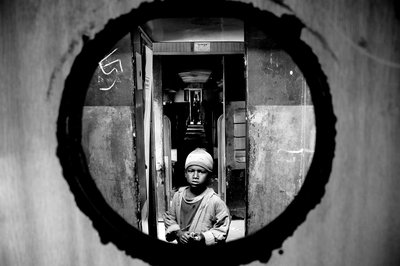 Portrait of a Street Child Seen Through the Door Hole of a Train Compartment at Kamalapur Rail Station in Dhaka, Bangladesh. January 5, 2007 by Unbekannt Unbekannt